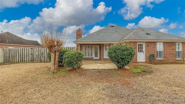 back of property featuring a patio and a lawn