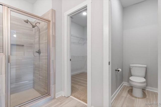 bathroom with toilet and an enclosed shower