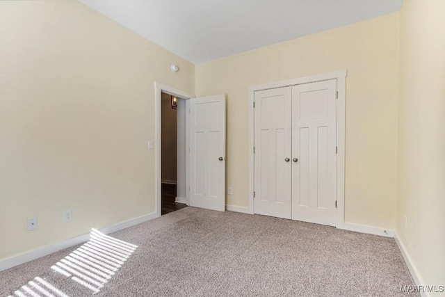 unfurnished bedroom featuring light carpet and a closet