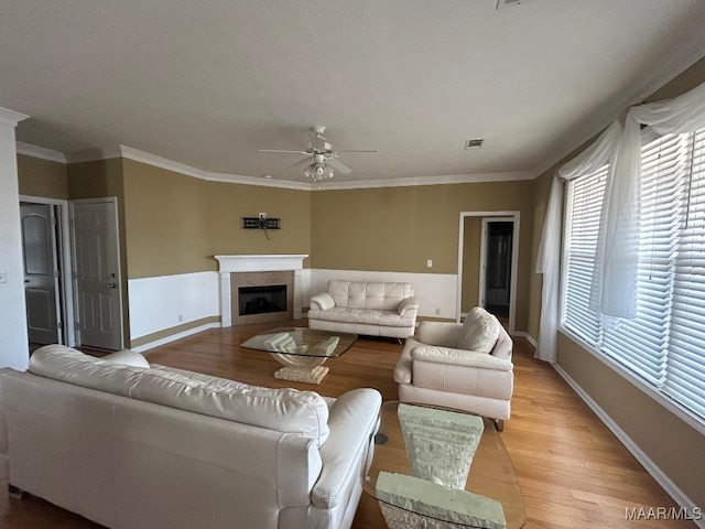 living room with crown molding, light hardwood / wood-style floors, and ceiling fan