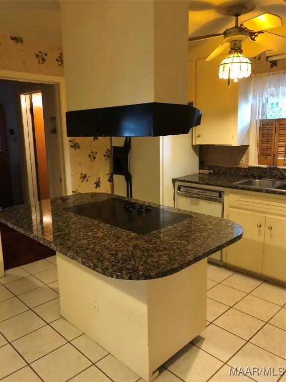 kitchen featuring island range hood, white cabinetry, sink, black electric stovetop, and light tile patterned floors