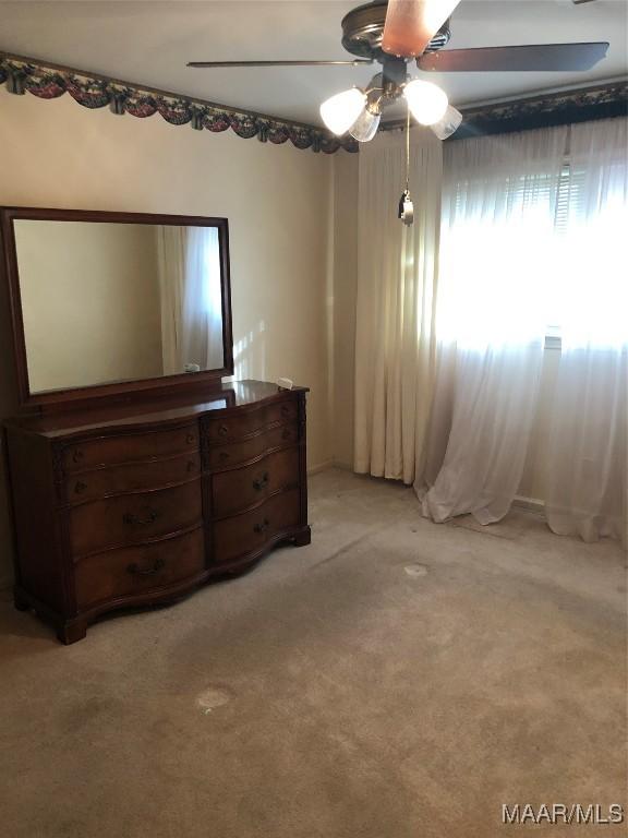 unfurnished bedroom featuring light carpet and ceiling fan