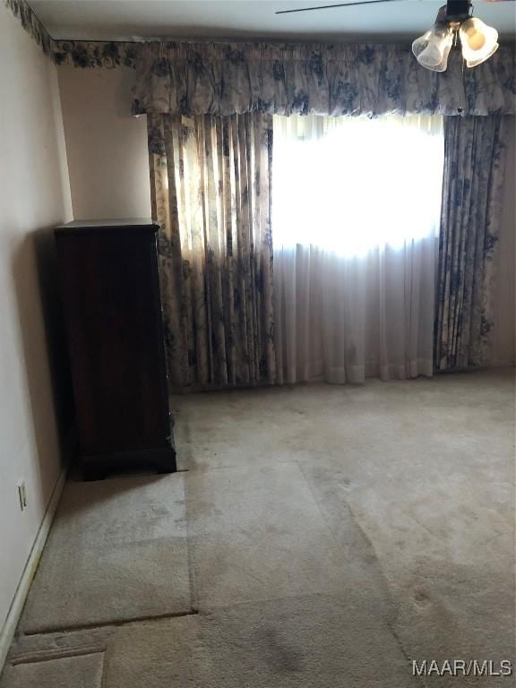 empty room featuring carpet floors and ceiling fan