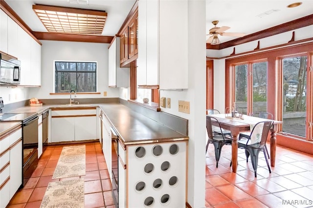 kitchen featuring light tile patterned flooring, sink, white cabinets, ceiling fan, and black range with electric stovetop