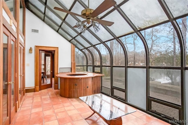 unfurnished sunroom with lofted ceiling and ceiling fan