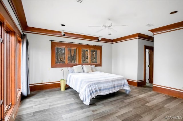 bedroom with ceiling fan, ornamental molding, and hardwood / wood-style floors