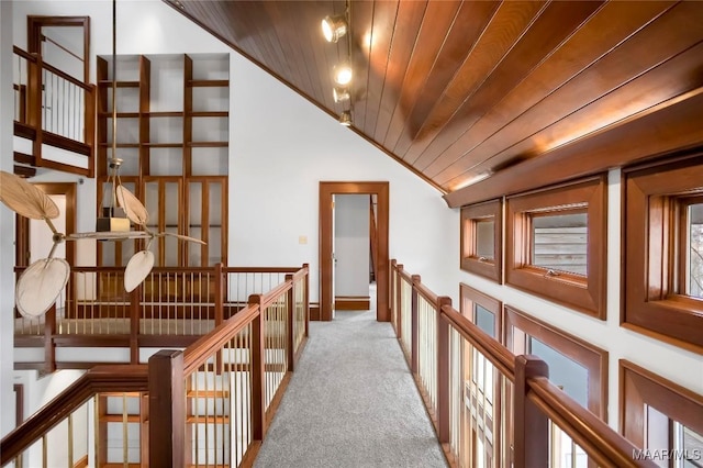 hall with wood ceiling, lofted ceiling, and light carpet