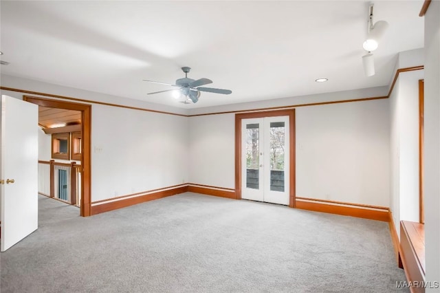 carpeted spare room featuring crown molding, french doors, and ceiling fan