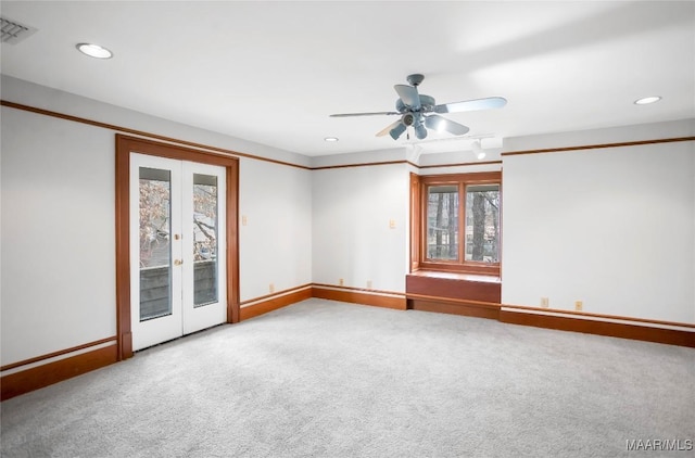 carpeted empty room featuring french doors and ceiling fan