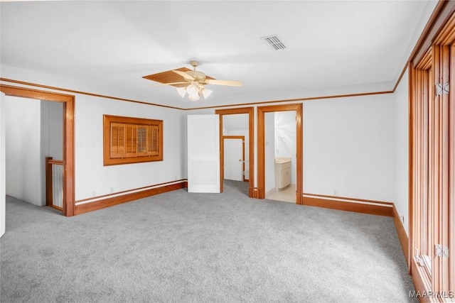 unfurnished bedroom featuring crown molding, light colored carpet, ensuite bathroom, and ceiling fan