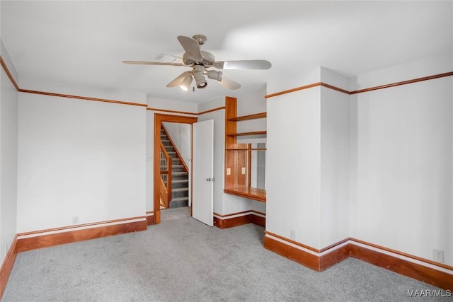 carpeted spare room featuring ceiling fan