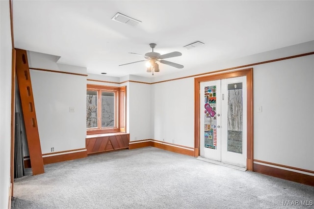 empty room featuring carpet floors, ceiling fan, and french doors