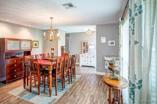 dining space with an inviting chandelier and hardwood / wood-style floors