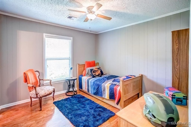 bedroom featuring hardwood / wood-style floors, crown molding, a textured ceiling, and ceiling fan