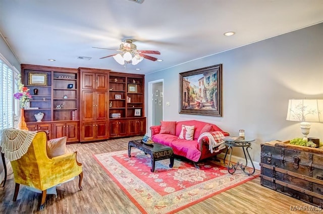 living room featuring ceiling fan and light hardwood / wood-style flooring