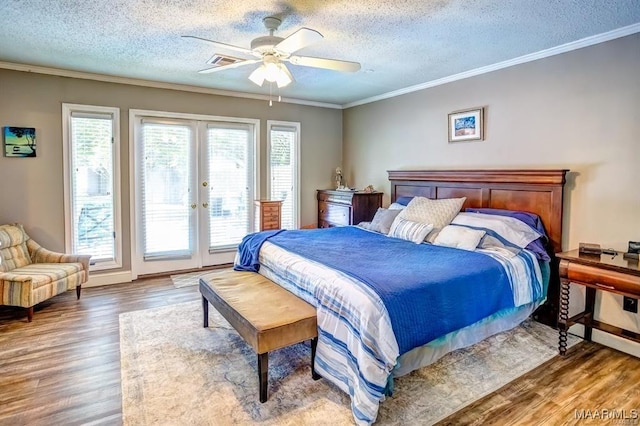 bedroom featuring french doors, crown molding, a textured ceiling, access to outside, and hardwood / wood-style floors