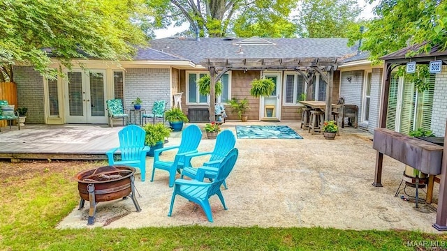 rear view of house with a pool side deck, a pergola, french doors, and an outdoor fire pit