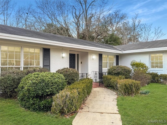 doorway to property featuring a lawn