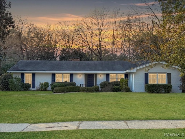 single story home featuring a lawn