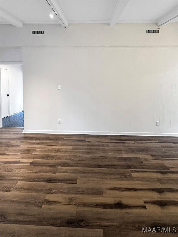 spare room with beamed ceiling, track lighting, and dark hardwood / wood-style floors