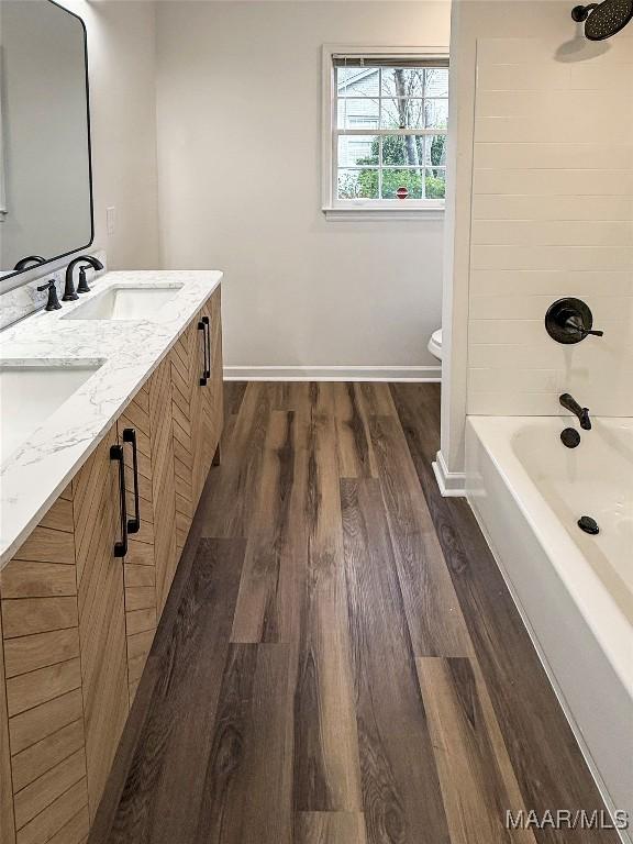 full bathroom with hardwood / wood-style flooring, vanity, toilet, and bathing tub / shower combination