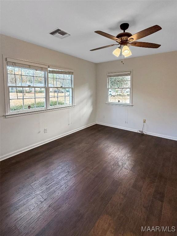 spare room with dark hardwood / wood-style floors and ceiling fan