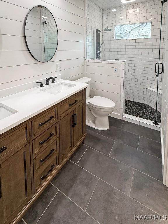 bathroom with tile patterned flooring, vanity, an enclosed shower, and toilet