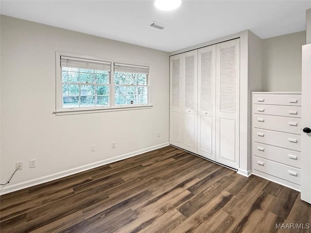 unfurnished bedroom featuring dark hardwood / wood-style floors and a closet