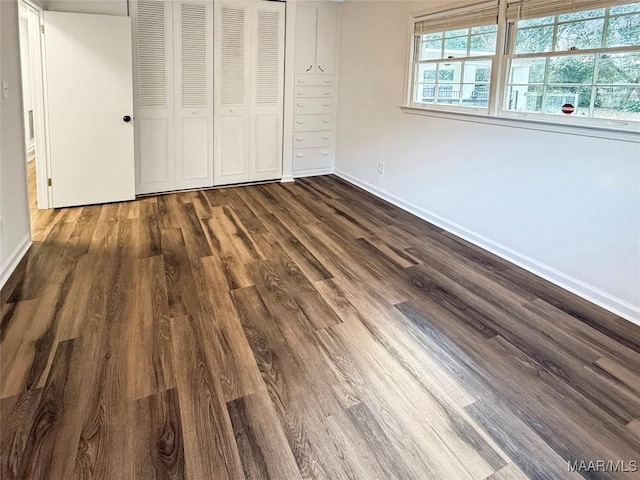 unfurnished bedroom featuring dark hardwood / wood-style flooring and a closet