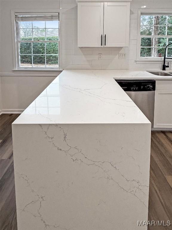 kitchen with dark hardwood / wood-style flooring, dishwasher, sink, and white cabinets