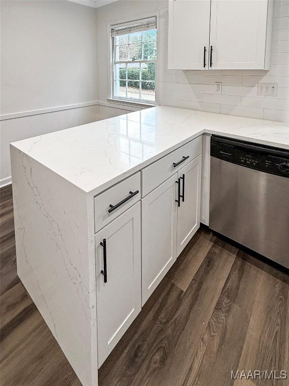 kitchen featuring white cabinetry, tasteful backsplash, light stone countertops, dark hardwood / wood-style flooring, and stainless steel dishwasher