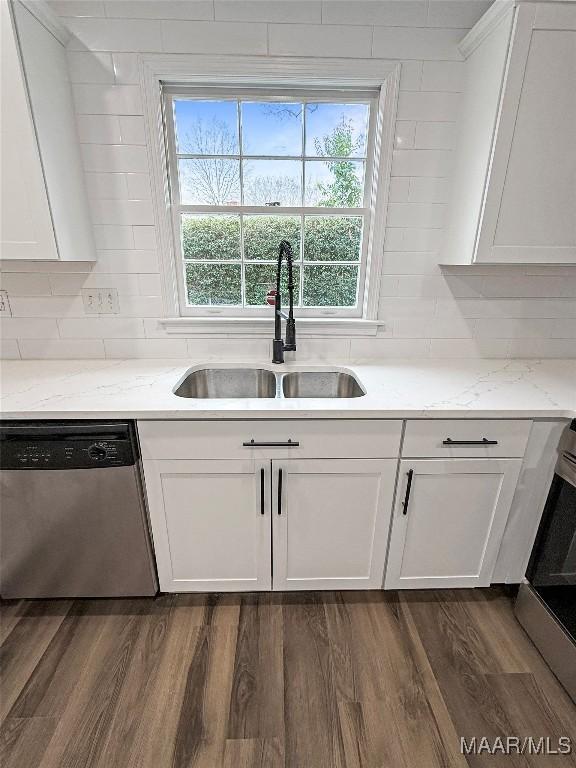 kitchen with sink, white cabinetry, light stone countertops, dark hardwood / wood-style flooring, and stainless steel dishwasher