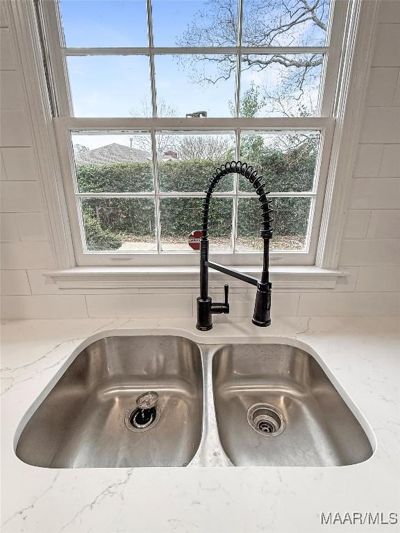 room details featuring light stone countertops and sink