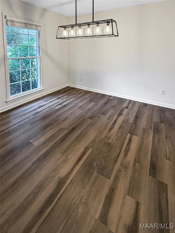 unfurnished dining area featuring dark hardwood / wood-style flooring