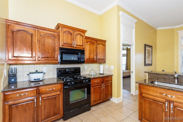 kitchen featuring sink, crown molding, tasteful backsplash, dark stone countertops, and black appliances