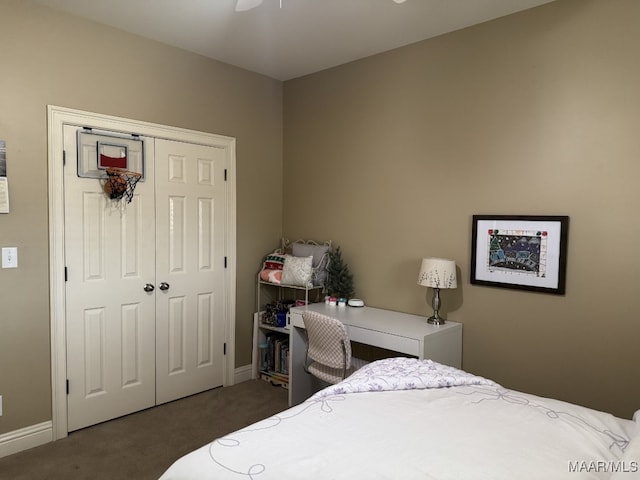 bedroom featuring ceiling fan, a closet, and dark colored carpet