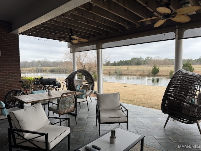 view of patio featuring outdoor lounge area, ceiling fan, and a water view