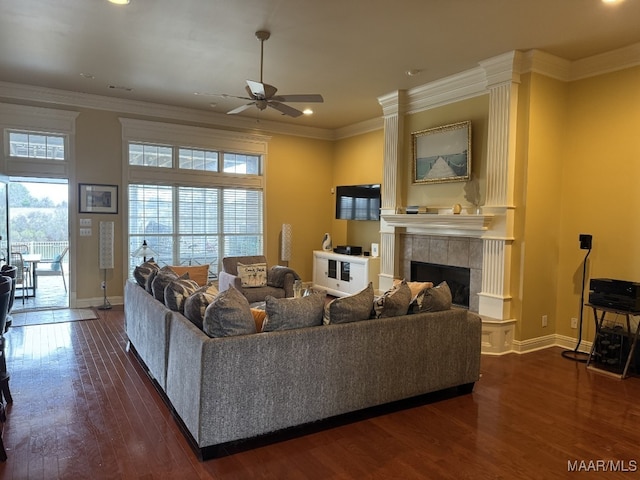 living room with ceiling fan, a fireplace, ornamental molding, and dark hardwood / wood-style flooring