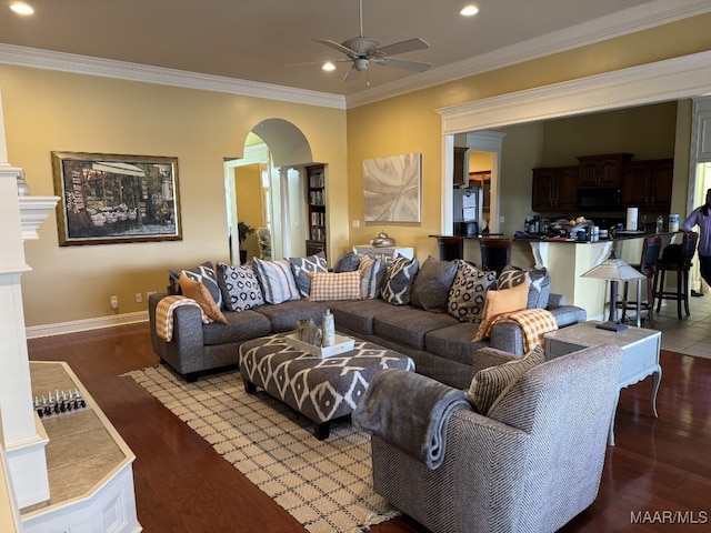 living room featuring crown molding, wood-type flooring, and ceiling fan