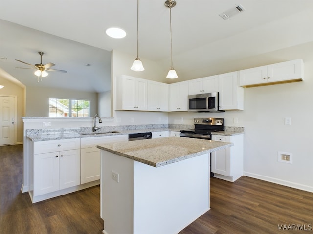 kitchen with sink, white cabinetry, decorative light fixtures, appliances with stainless steel finishes, and a kitchen island