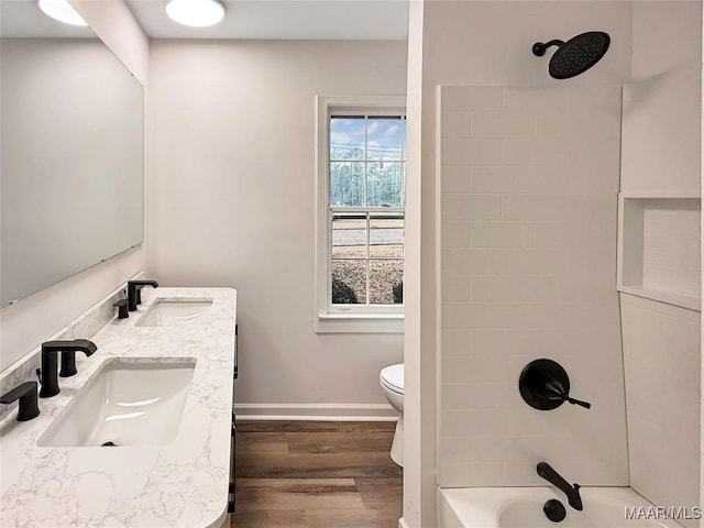 full bathroom featuring tiled shower / bath, hardwood / wood-style floors, vanity, and toilet