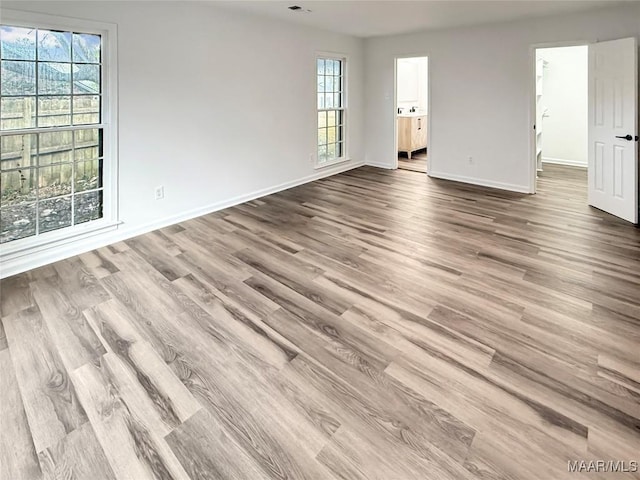 empty room featuring baseboards and wood finished floors