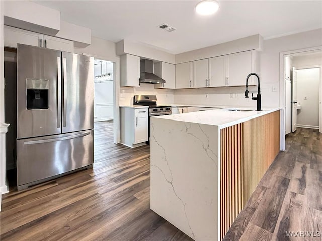 kitchen with sink, white cabinetry, stainless steel appliances, light stone countertops, and wall chimney exhaust hood