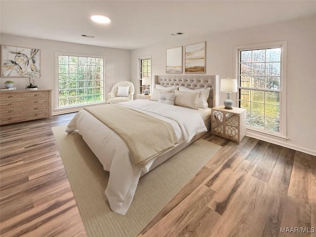 bedroom with recessed lighting, baseboards, visible vents, and wood finished floors