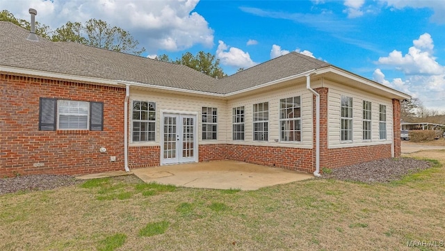 back of house featuring french doors, brick siding, a yard, and a patio