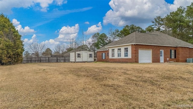 exterior space featuring a storage shed, a yard, central air condition unit, and a garage