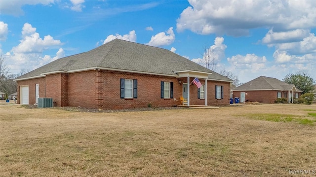 view of front of property featuring central AC unit, a garage, and a front yard