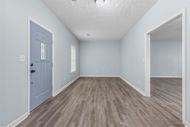 foyer entrance featuring wood finished floors, a textured ceiling, and baseboards