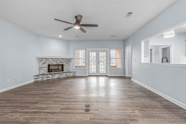 unfurnished living room with french doors, ceiling fan, dark hardwood / wood-style floors, and a textured ceiling