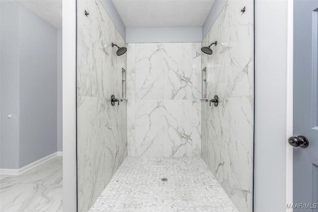 bathroom featuring marble finish floor, a textured ceiling, and a marble finish shower